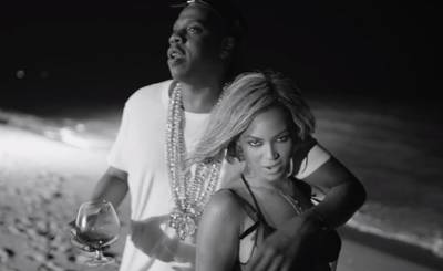 Surfboard Style - Oh, yes, the singer and her hubby are just as hot in the official video for “Drunk in Love,” where Bey serenades her man in a vintage Eres bikini and sheer Wendy Nichols dress. Hov complements her perfectly in a crisp, white tee and mounds of gold chains. (Photo: Columbia Records)&nbsp;