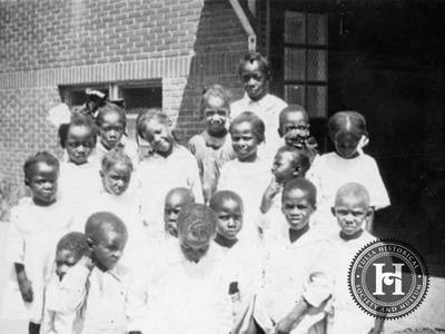 Rescued - African American children in the care of the American Red Cross stand near the Booker T. Washington High School.