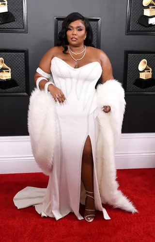 Lizzo wears golden disco ball outfit on stage and navy gown with thigh slit  on carpet at BET Awards