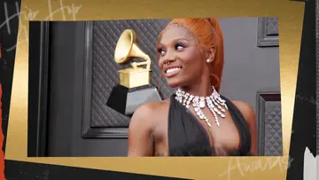 Artist Doechii pictured in a black dress and pink necklace on the Grammy's red carpet.