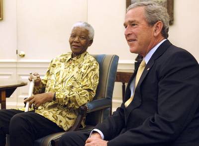America Bound - In 2005, President George W. Bush invited Mandela to the White House, where they shared a few laughs in the Oval Office.&nbsp;(Photo: Mannie Garcia/Getty Images)