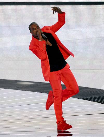 Thou Shalt Be Seen - ‘Ye loves taking fashion to a new level, choosing flashy hues like red to assert his sartorial dominance.   (Photo: Kevin Winter/Getty Images)