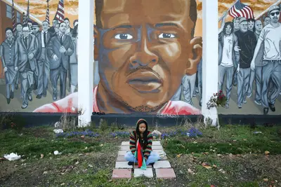 Mourning Continues - Woman sits near a mural of Freddie Gray near the corner where his deadly arrest occurred.&nbsp;   (Photo: Patrick Semansky/ AP PHOTO)