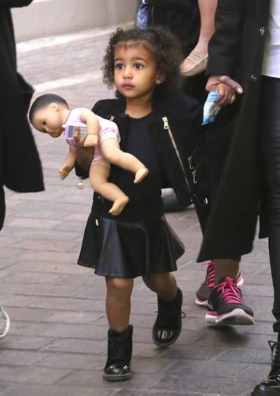 Curls Out - For a visit to see Santa, North's curls were in full effect. She also wears a black leather skater skirt, a must-have item this season. (Photo: Splash News)