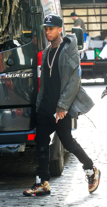 Kylie wearing gray pumps and Tyga wearing Supreme x Jordan sneakers