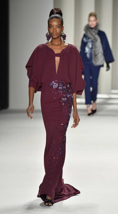 Carolina Herrera - Model Maria Borges is breathtaking in this berry ball gown with dramatic caped sleeves and crystal accents. And those petal-inspired earrings? Just divine.  (Photo: Frazer Harrison/Getty Images for Mercedes-Benz Fashion Week)