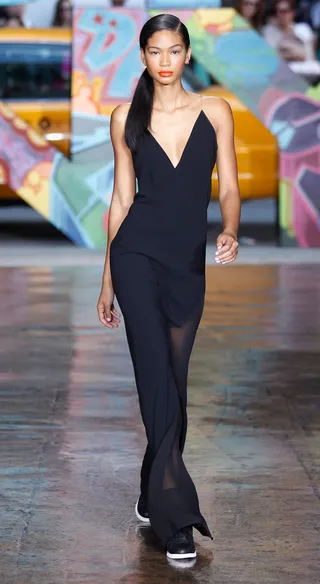 DKNY Spring 2014 - Chanel Iman is a vision in black in this slinky cocktail gown. Gorgeous! We also love how the the brand stays true to its street style roots by outfitting models in sporty wedge sneakers.  (Photo: Peter Michael Dills/Getty Images)