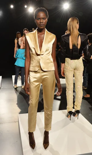 David Tlale Spring 2014 model - This gold pantsuit exemplifies the bold color palette and expert tailoring we come to expect from the South African designer.  (Photo: Slaven Vlasic/Getty Images for Mercedes-Benz Fashion Week)