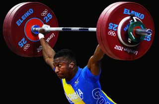 Weight on His Shoulders - Oscar Albeiro Figueroa Mosquera of Colombia lifts a sizeable load during the men's 62kg weightlifting competition. (Photo: Laurence Griffiths/Getty Images)