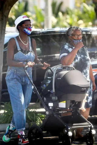 Family Time! - Jodie Turner-Smith stepped out with her mom, and infant daughter yesterday in LA. The actress headed to Wholefoods wearing a pair of Denim overalls and Melody Esani x Air Jordan 1 sneakers ($800). The new mom made sure to have on a face covering as they went for their stroll. It looks like Jodie is adjusting to motherhood very well.&nbsp; (Photo: Backgrid) (Photo: Backgrid)