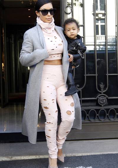 Holy Grail - Leave it to Kim to make a statement! A hole-punctured crop top and high-waist trousers (both by Chanel) give off a punk vibe that complements her daughter?s all-leather look perfectly.&nbsp;(Photo: Ralph,PacificCoastNews)