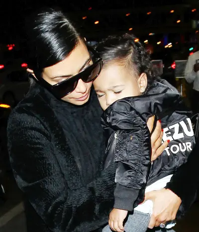 A Mother's Love - Kim Kardashian&nbsp;nuzzles a sleepy&nbsp;North West at Los Angeles International Airport as the pair board a flight.(Photo: Splash News)