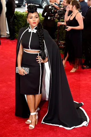 Janelle Monae - The “Yoga” songstress takes a turn in a caped H&amp;M ensemble complete with a coordinating crop top and fitted skirt. She accessorizes with white open-toe sandals and a chunky side braid with luscious height at the crown.  (Photo: Jamie McCarthy/FilmMagic)