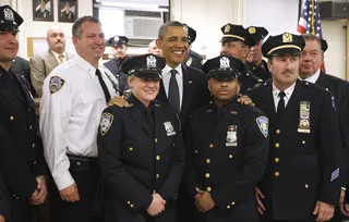 Photo Op\r - The president shares a light moment with New York's Bravest.&nbsp;\r(Photo: AP Photo/Charles Dharapak)