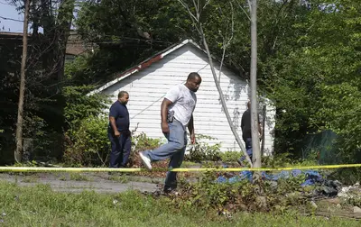 Discovering the Bodies - A neighbor reported a foul smell coming from a vacant home on Friday, leading police to the first body found in a garage. On Saturday, two more bodies were found — one in a backyard and one in a basement. Authorities say the bodies were found 100 to 200 yards apart. (Photo: AP Photo/Tony Dejak)
