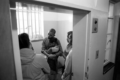Never Forget - The Obama family shares a poignant moment during their tour of former South African President Nelson Mandela's cell at &nbsp;Robben Island Prison.(Photo: Official White House Photo by Pete Souza)&nbsp;