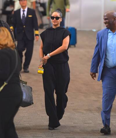 New York State Of Mind - Rihanna's calm flex is always a casually slay. She was captured in the airport keepin it cute in her all black ensemble that she accesorized with a mini $1k taxi themed bag. (Photo: Splash News)