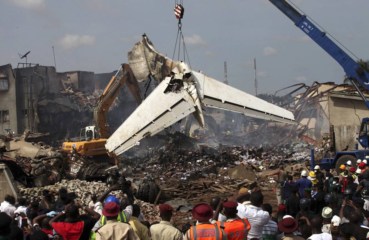 Fears of On-Ground Deaths From Nigeria Plane Crash - An American-built airliner crashed in Nigeria Sunday, killing all 153 people aboard. Now, as workers begin cleaning the wreckage, rescue officials say they fear many more people may have perished on the ground.(Photo: REUTERS/Akintunde Akinleye)