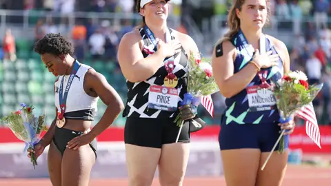 EUGENE, OREGON - JUNE 26: Gwendolyn Berry (L), third place, looks on during the playing of the national anthem with DeAnna Price (C), first place, and Brooke Andersen, second place, on the podium after the Women's Hammer Throw final on day nine of the 2020 U.S. Olympic Track & Field Team Trials at Hayward Field on June 26, 2021 in Eugene, Oregon. (Photo by Patrick Smith/Getty Images)