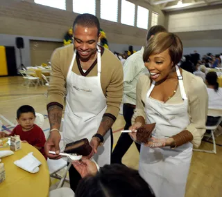 Meet the Browns\r - Newlyweds Monica and hubby Shannon Brown of the L.A. Lakers serve meals to families at the kick-off for Feeding America's Hunger Action Month with 300 lunches provided by the Cheesecake Factory at Maywood Parks and Recreation Center in Maywood, California. (Photo: John Shearer/Getty Images via Feeding America)
