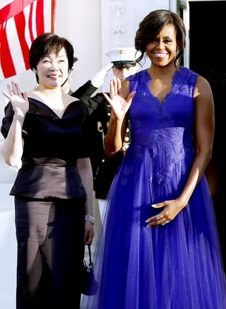 And the Winner is... - The first lady chose a rich purple gown design by the Japanese-born designer Tadashi Shoji that featured embroidered feathers and a plunging neckline. (Photo: Jonathan Ernst /Landov)