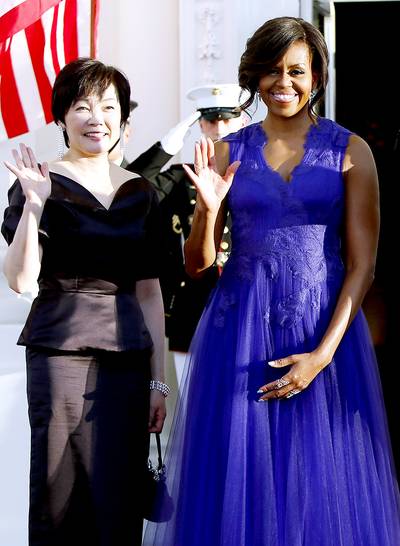 And the Winner is... - The first lady chose a rich purple gown design by the Japanese-born designer Tadashi Shoji that featured embroidered feathers and a plunging neckline. (Photo: Jonathan Ernst /Landov)