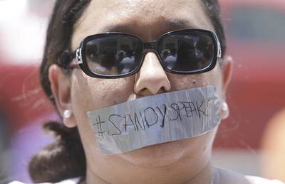 #SandySpeaks - Vanessa Myers, a protester, wears tape on her mouth with the label #SandySpeaks, the name of a video series that she created in response to social injustices.(Photo: Melissa Phillip/Houston Chronicle via AP)