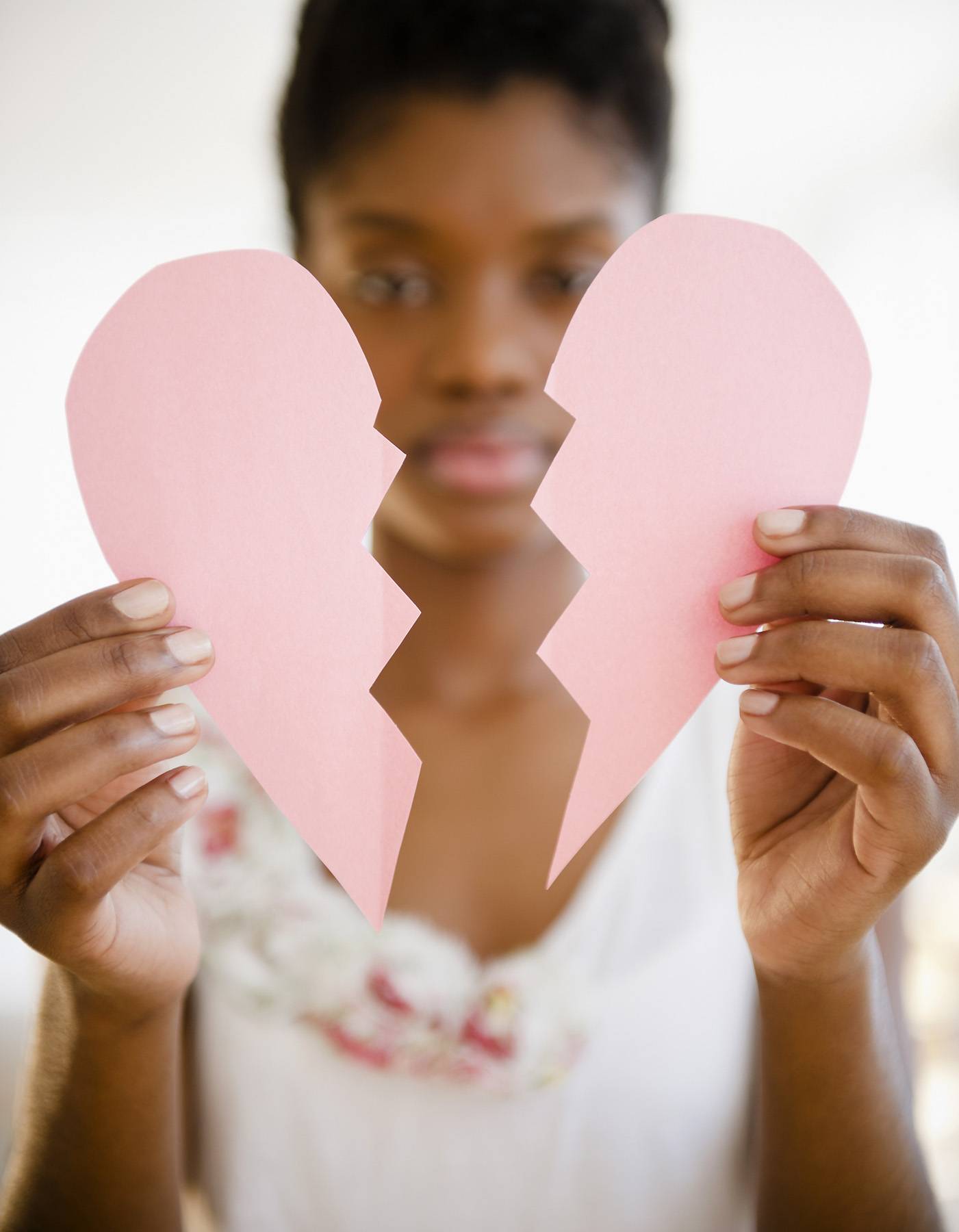 Black woman holding broken paper heart