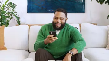 Anthony Anderson looking at his phone.