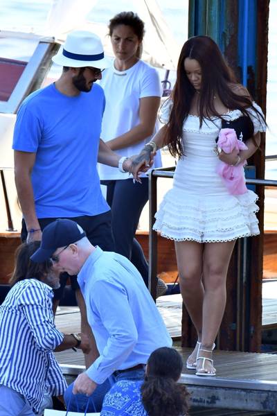 Boo'd Up&nbsp; - Rihanna was photographed hanging out on a yacht in Italy with her rumored billionaire boyfriend, Jameel. She is seen wearing an ivory Zimmermann ruffled dress ($850) from their summer swim collection. Rih accessorized with a $30 New Era Yankees cap. Rih is holding it for this photo but was seen sporting it earlier in the day. We love the round the way Rih!&nbsp; (Photo: Backgrid)