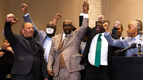 George Floyd's brother Philonise Floyd (C), flanked by Reverend Al Sharpton (2nd L) and Attorney Ben Crump (R), hold up their arms during a press conference following the verdict in the trial of former police officer Derek Chauvin in Minneapolis, Minnesota on April 20, 2021. - Sacked police officer Derek Chauvin was convicted of murder and manslaughter on april 20 in the death of African-American George Floyd in a case that roiled the United States for almost a year, laying bare deep racial divisions. (Photo by Kerem Yucel / AFP) (Photo by KEREM YUCEL/AFP via Getty Images)