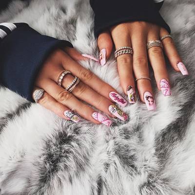 Kylie Jenner - King Kylie’s nail game is royal. Here she is stuntin’ with hot pink Barbie-themed nail art that also includes a throwback Britney Spears decal on her right middle finger. (Photo: Kylie Jenner via Instagram)