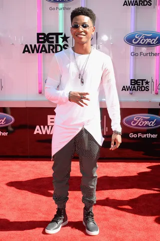 Jacob Latimore - The young R&amp;B star stays on-trend in a layered white topper and patterned trousers, adding two-tone aviators and gray high-tops to his stylish look.  (Photo: Earl Gibson III/Getty Images for BET)