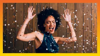 A stunning looking woman dancing at a party with confetti falling around her