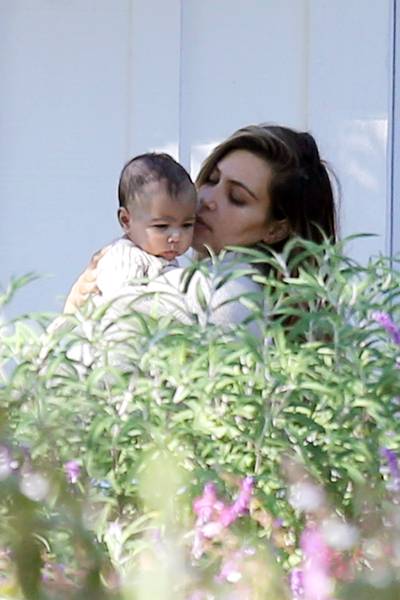 Hello, Baby - Kim Kardashian gives baby North a little sunlight on the balcony of their L.A. home. (Photo: Splash News)
