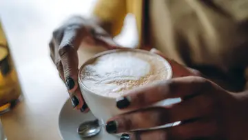 African-american woman drinking coffee. Close up.