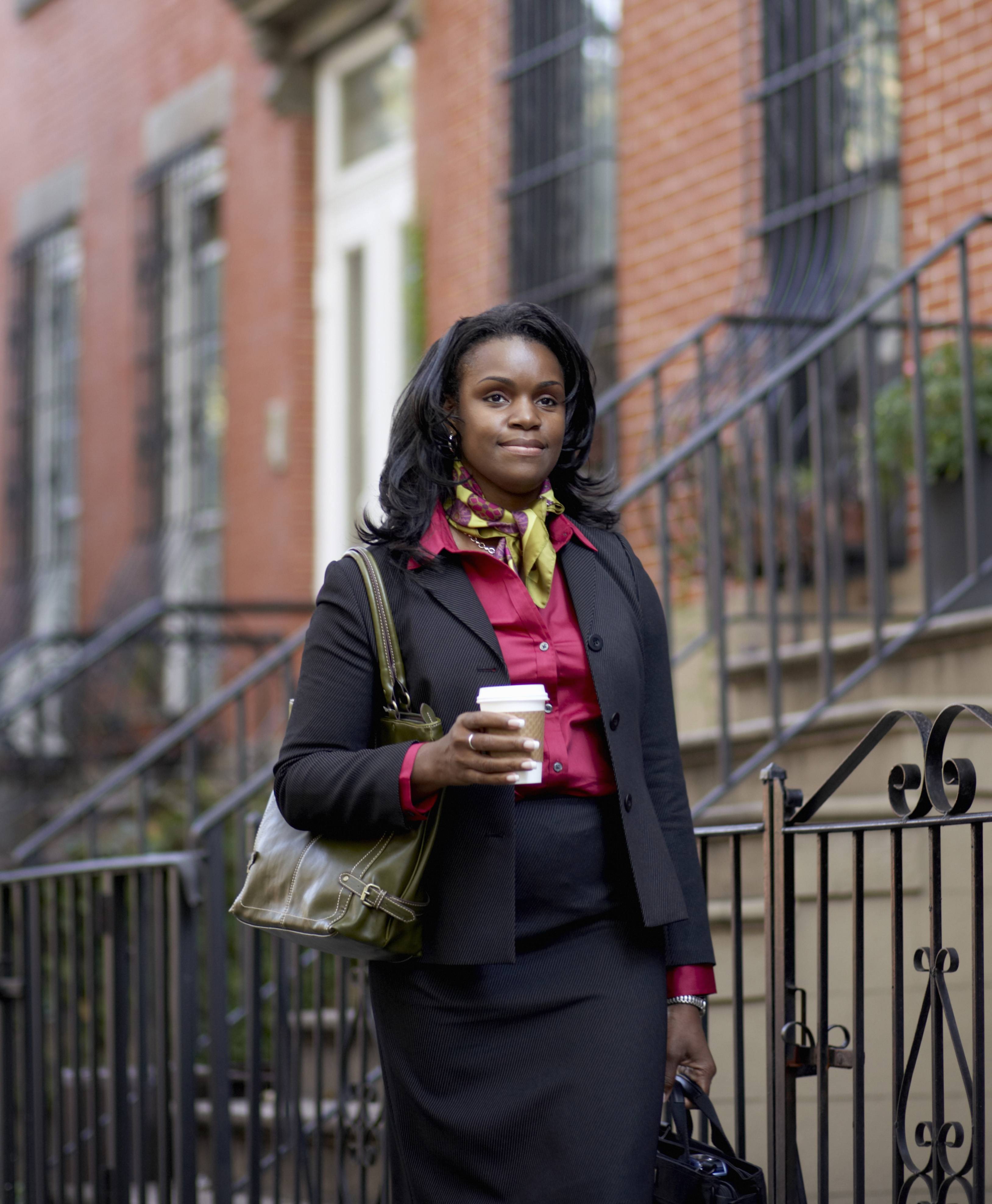 woman walking to work in the city, holding coffee