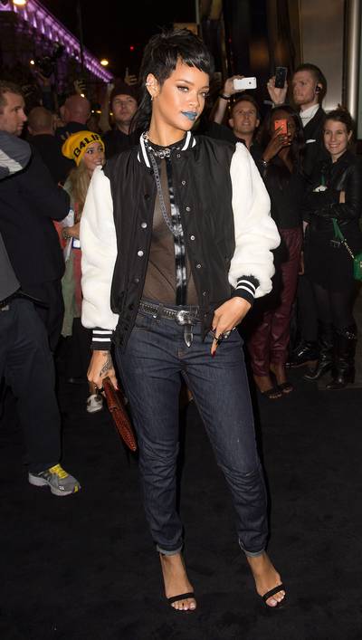 Rihanna - At a London photo call for her new River Island collection, the star turns heads with a cool blue pout, varsity jacket and cuffed skinnies.  (Photo: Samir Hussein/Getty Images)