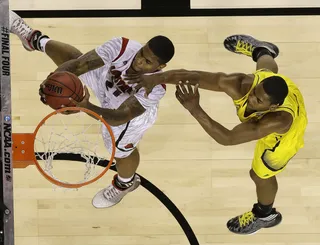 So Close - Michigan forward Glenn Robinson III couldn't keep Louisville's&nbsp;Chane Behanan away from the net.&nbsp;Robinson made two free throws with two seconds left to give Michigan a 38-37 lead at halftime.&nbsp;(Photo: AP Photo/Charlie Neibergall)