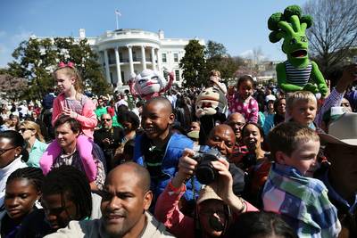 Over There! - Visitors look on and snap photos as Obama reads a book to children on the White House tennis court.  (Photo: Mark Wilson/Getty Images)