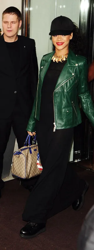 Cheerio - Rihanna gives a smile to the paps as she leaves her hotel in London wearing a hunter green leather jacket and long black dress.  (Photo: ZTimages.com, PacificCoastNews.com)