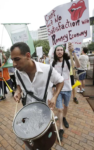 Bang the Drum Loudly - Ganzalo Valdes marches with demonstrators.(Photo: AP Photo/Dave Martin)