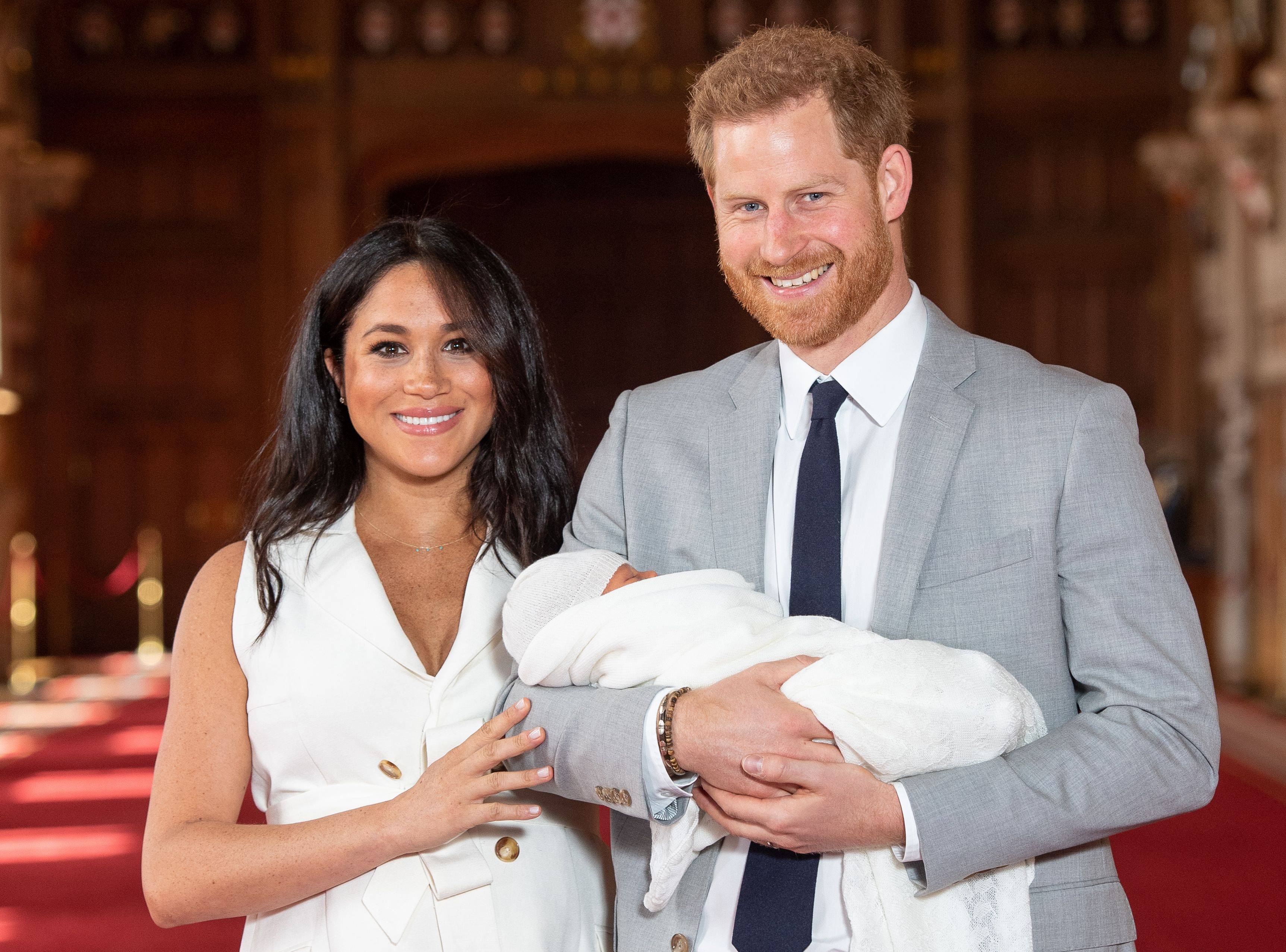 TOPSHOT - Britain's Prince Harry, Duke of Sussex (R), and his wife Meghan, Duchess of Sussex, pose for a photo with their newborn baby son, Archie Harrison Mountbatten-Windsor, in St George's Hall at Windsor Castle in Windsor, west of London on May 8, 2019. (Photo by Dominic Lipinski / POOL / AFP)        (Photo credit should read DOMINIC LIPINSKI/AFP via Getty Images)