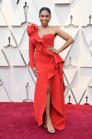 Chic In Red - Jennifer Hudson looked glamorous in a ruffled one-shoulder gown by Elie Saab which she paired with strappy silver Nicholas Kirkwood sandals and jewelry by Harry Winston at the 2019 Oscars. (Photo: Steve Granitz/WireImage)
