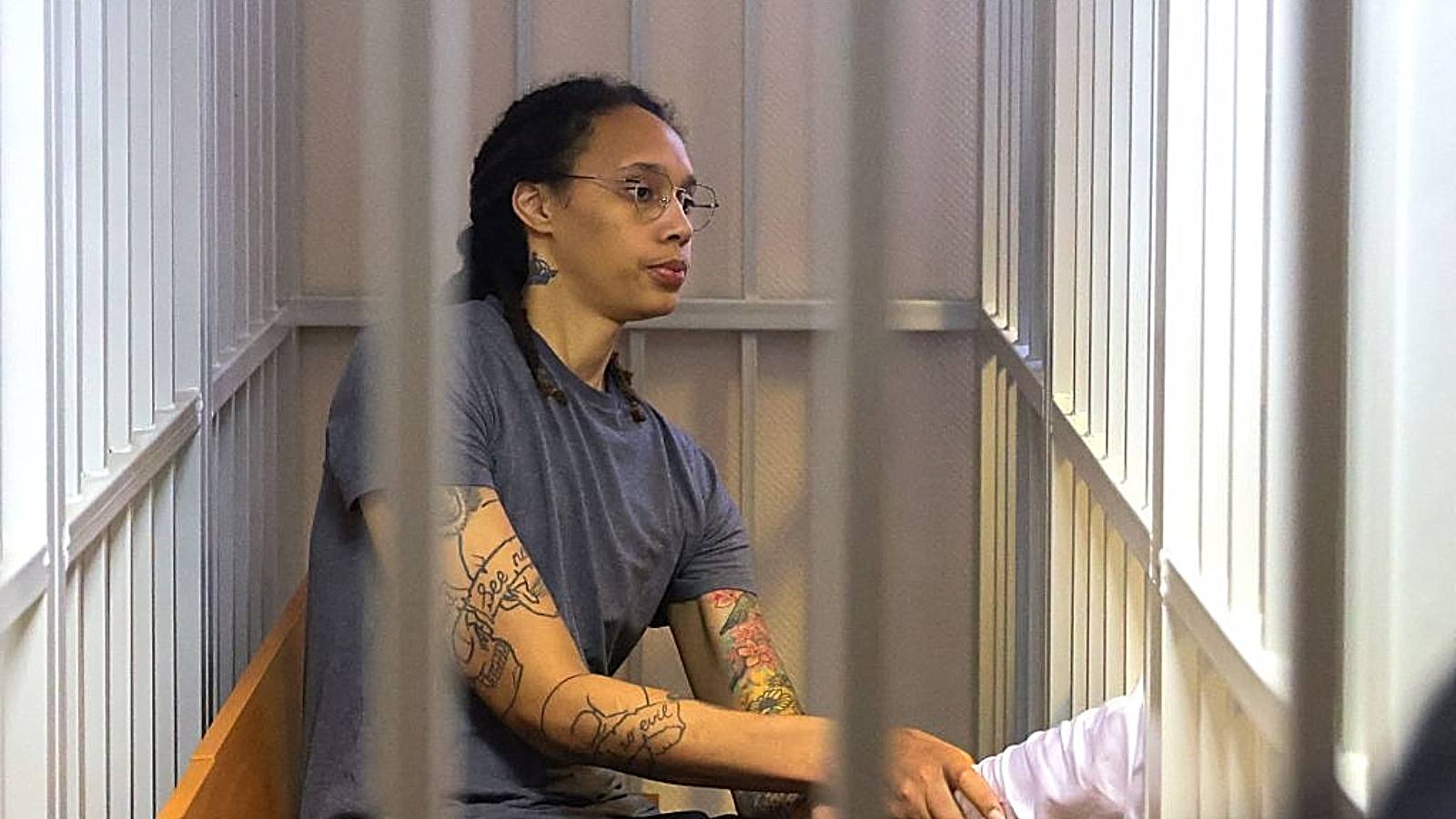 US Women's National Basketball Association (WNBA) basketball player Brittney Griner, who was detained at Moscow's Sheremetyevo airport and later charged with illegal possession of cannabis, sits inside a defendants' cage after the court's verdict during a hearing in Khimki outside Moscow, on August 4, 2022. - A Russian court found Griner guilty of smuggling and storing narcotics after prosecutors requested a sentence of nine and a half years in jail for the athlete 