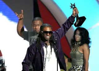 Lil Wayne - The New Orleans rapper holds up his Best Male Rapper Artist award onstage at the Shrine Auditorium in Los Angeles. (Photo: Vince Bucci/PictureGroup)