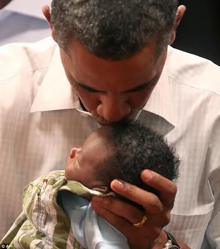 Bundle of Joy - Obama upholds the presidential tradition of kissing babies.&nbsp;(Photo: Associated Press)