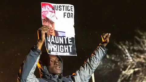 A demonstrator holds a photo of Daunte Wright and shouts "Don't shoot" at the police after curfew as people protest the death of Daunte Wright who was shot and killed by a police officer in Brooklyn Center, Minnesota on April 13, 2021. - Tensions have soared over the death on April 11 of African American Daunte Wright near the Midwestern US city, a community already on edge over the ongoing trial of a policeman accused of killing another Black man, George Floyd. (Photo by Kerem YUCEL / AFP) (Photo by KEREM YUCEL/AFP via Getty Images)