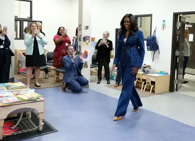 Denim On Denim - Michelle Obama surprised the students and staff of Para Los Niños school yesterday (Nov. 15). The former first lady stepped out in a full denim look that she paired perfectly with a pair of tan booties. (Photo: Sarah Morris/Getty Images)