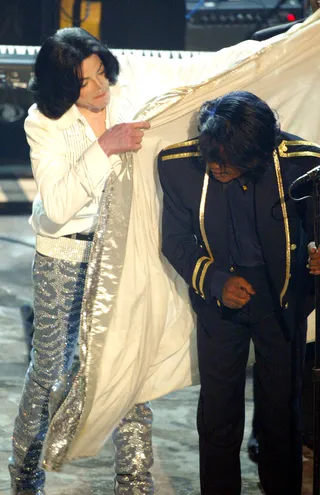 Legends Come Together - Michael Jackson helps James Brown with his cape in this historic performance at the 2003 BET Awards. (Photo: Kevin Winter/Getty Images)